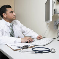 Doctor looking at computer screen Doctor looking at computer screen