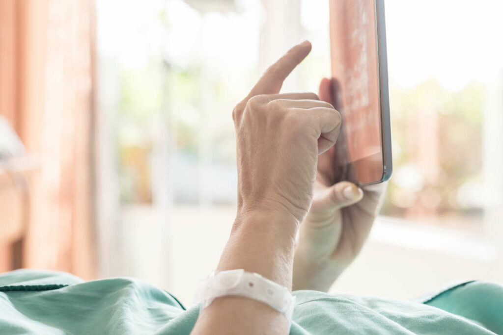 Mature female patient used tablet on bed in hospital