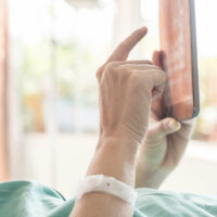 Mature female patient used tablet on bed in hospital Mature female patient used tablet on bed in hospital