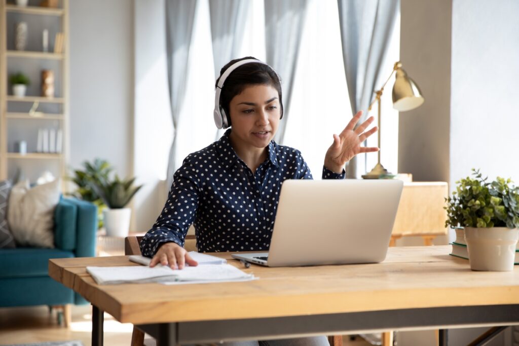 Indian student wear headphones use laptop e-learning remotely by videocall