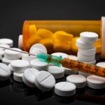 Opioid epidemic and drug abuse concept with a heroin syringe or other narcotic substances next to a bottle of prescription opioids. Oxycodone is the generic name for a range of opioid painkillers Opioid epidemic and drug abuse concept with a heroin syringe or other narcotic substances next to a bottle of prescription opioids. Oxycodone is the generic name for a range of opioid painkillers