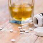 glass of alcohol and pills on table glass of alcohol and pills on table